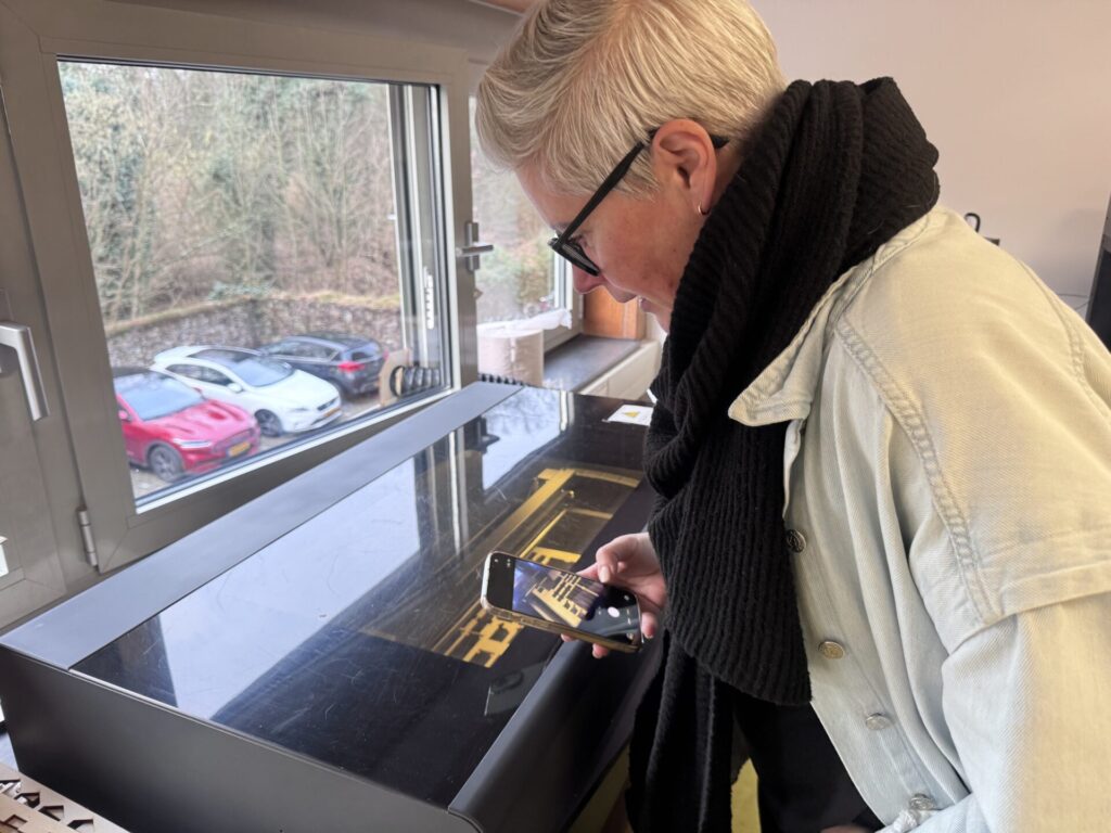 Deelnemer van workshop lasersnijden staat bij lasersnijder
